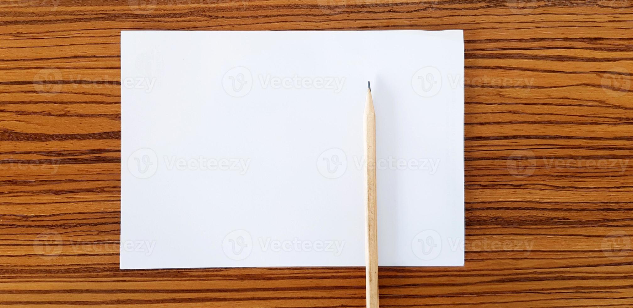 Brown pencil with white paper putting on wooden table with copy space for fill text. Education, Document and Object concept photo