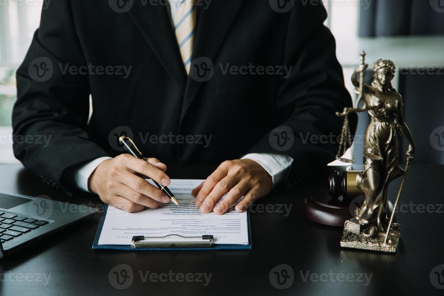 Justice and Law concept. Legal counsel presents to the client a signed contract with gavel and legal law or legal having team meeting at law firm in background photo