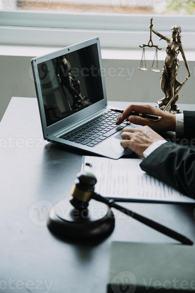 Justice and Law concept. Legal counsel presents to the client a signed contract with gavel and legal law or legal having team meeting at law firm in background photo