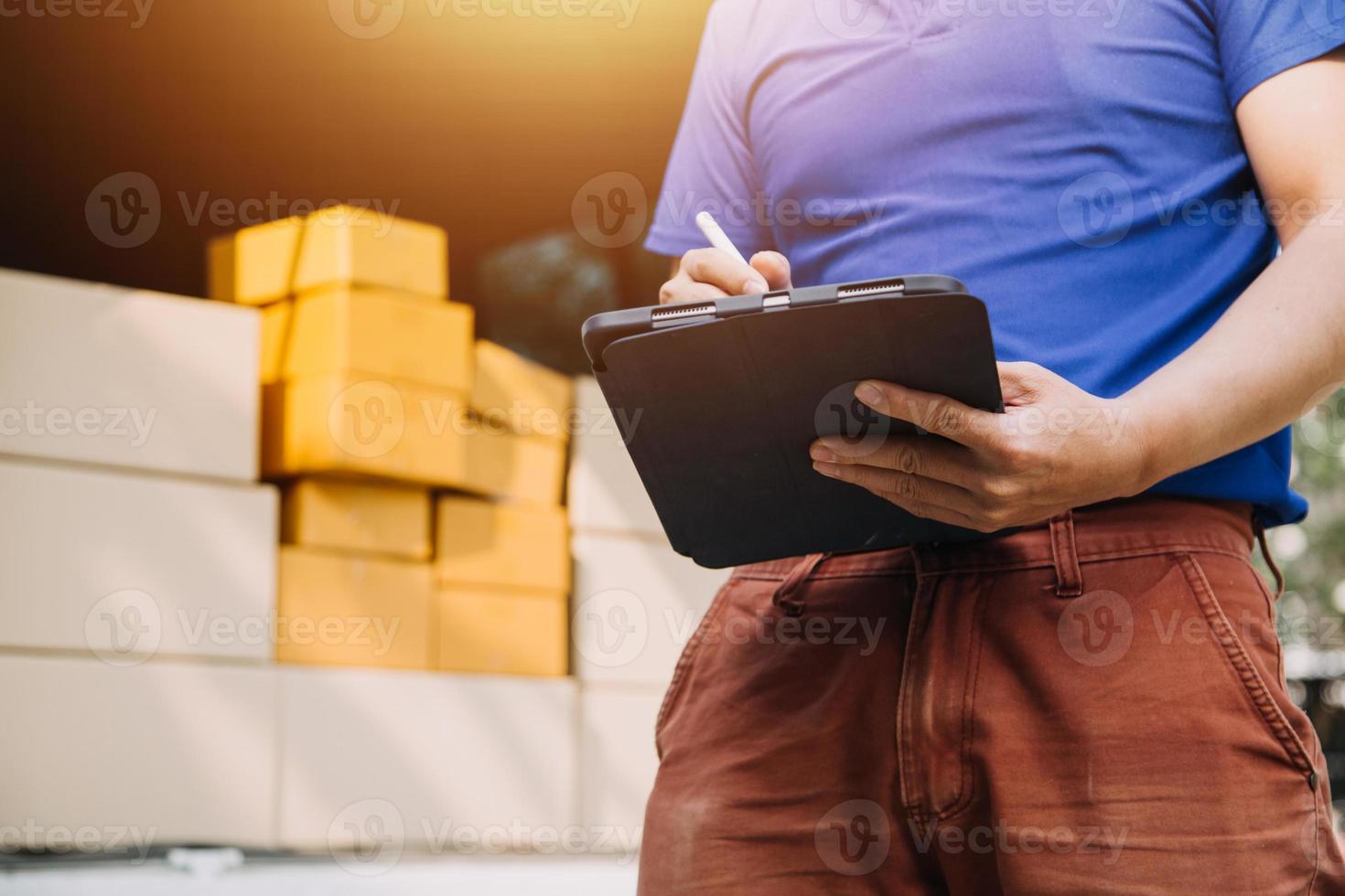 Delivery man with protective mask and gloves delivering parcels during lockdown and pandemic and holding mobile contactless payment machine photo