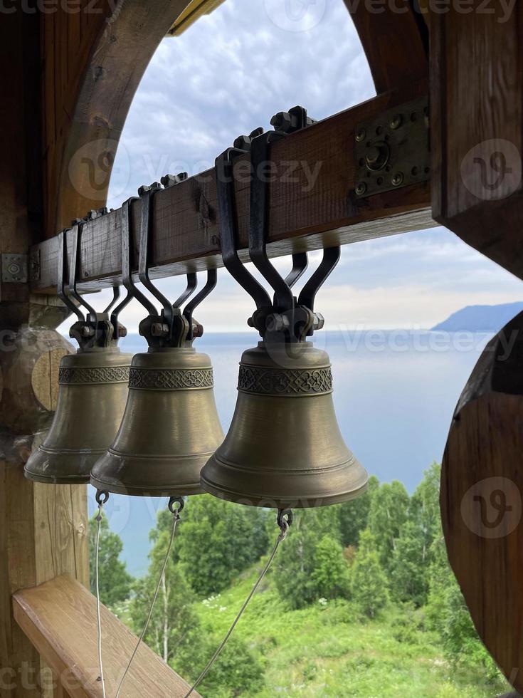 campanas en el campanario de un cristiano Iglesia en contra el fondo de lago Baikal, Rusia foto