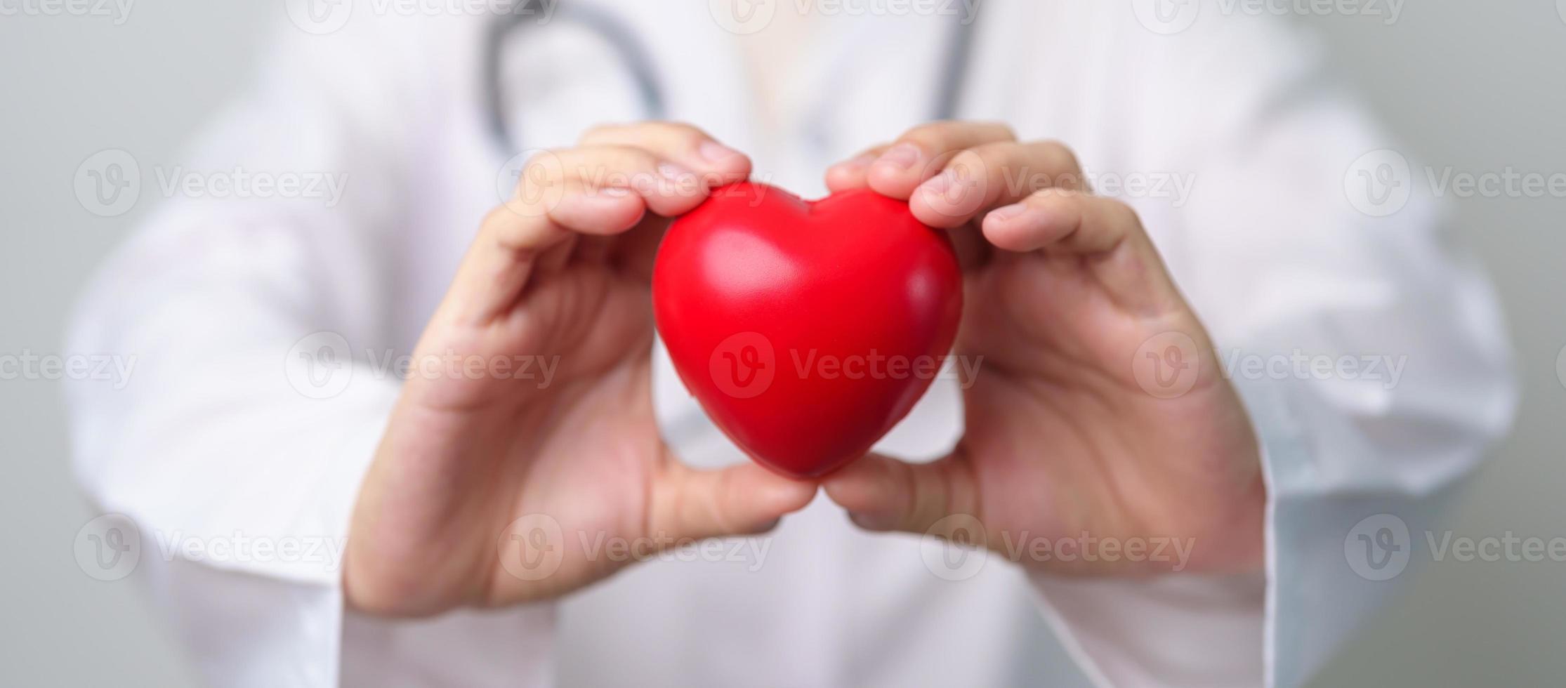 Doctor hand holding red heart shape in hospital. love, donor, world heart day, world health day, CSR donation and Insurance concepts photo