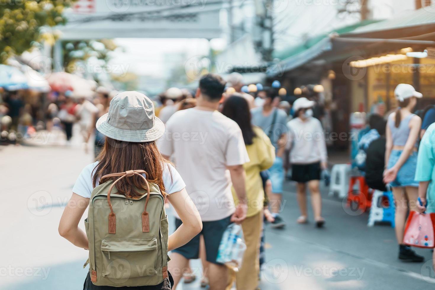 woman traveler visiting in Bangkok, Tourist with backpack and hat sightseeing in Chatuchak Weekend Market, landmark and popular attractions in Bangkok, Thailand. Travel in Southeast Asia concept photo