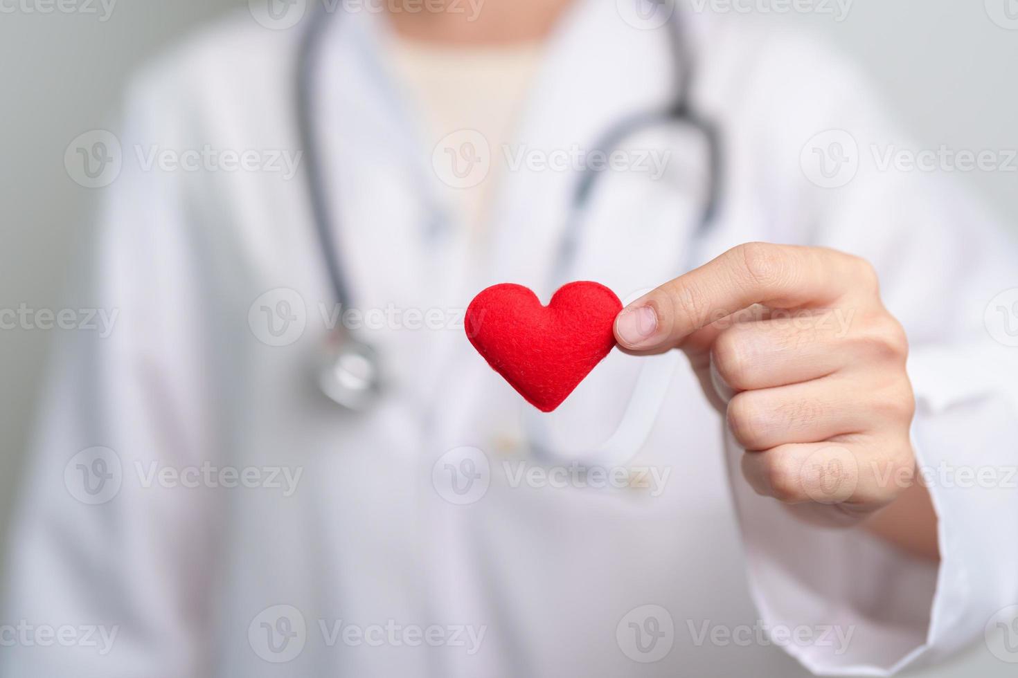 Doctor hand holding red heart shape in hospital. love, donor, world heart day, world health day, CSR donation and Insurance concepts photo