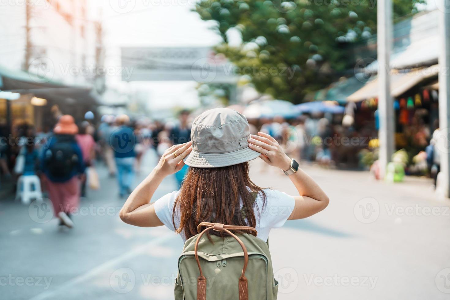 woman traveler visiting in Bangkok, Tourist with backpack and hat sightseeing in Chatuchak Weekend Market, landmark and popular attractions in Bangkok, Thailand. Travel in Southeast Asia concept photo