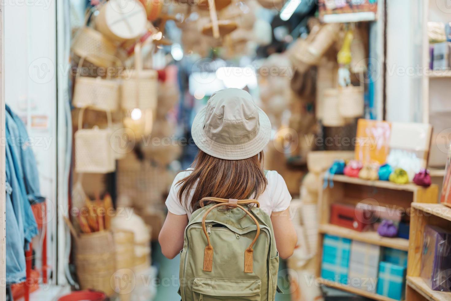 woman traveler visiting in Bangkok, Tourist with backpack and hat sightseeing in Chatuchak Weekend Market, landmark and popular attractions in Bangkok, Thailand. Travel in Southeast Asia concept photo
