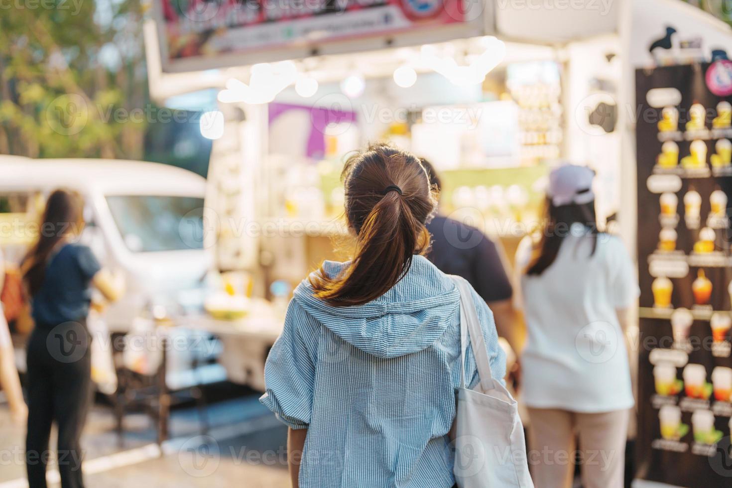 woman traveler visiting in Food Truck Market, Tourist with bag sightseeing in Weekend Market street photo