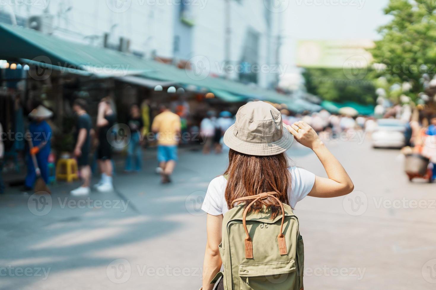 woman traveler visiting in Bangkok, Tourist with backpack and hat sightseeing in Chatuchak Weekend Market, landmark and popular attractions in Bangkok, Thailand. Travel in Southeast Asia concept photo