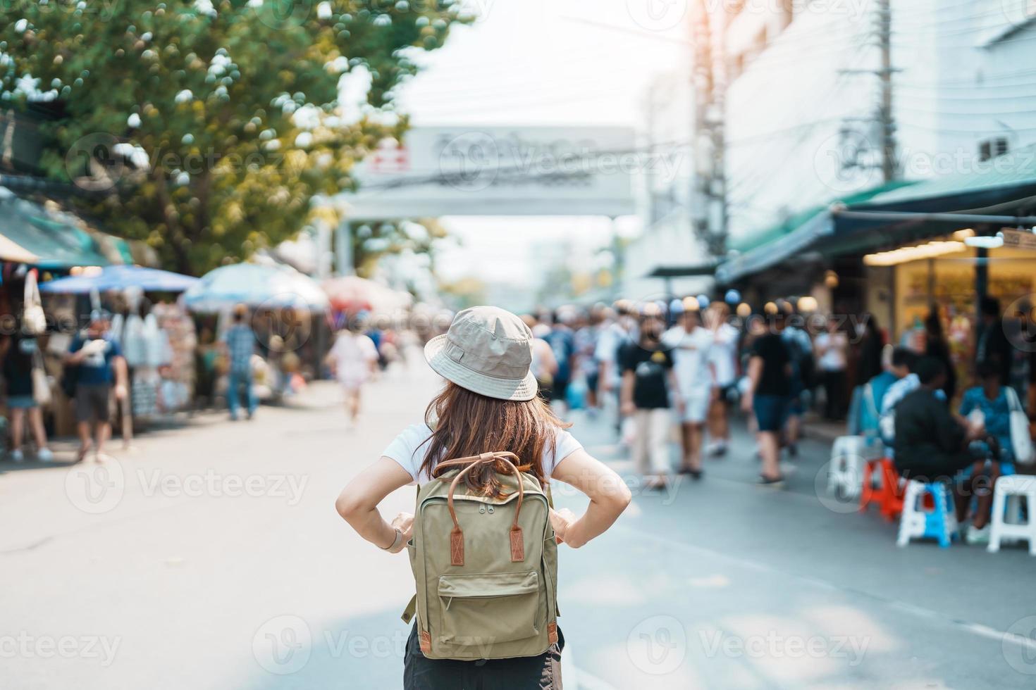 woman traveler visiting in Bangkok, Tourist with backpack and hat sightseeing in Chatuchak Weekend Market, landmark and popular attractions in Bangkok, Thailand. Travel in Southeast Asia concept photo
