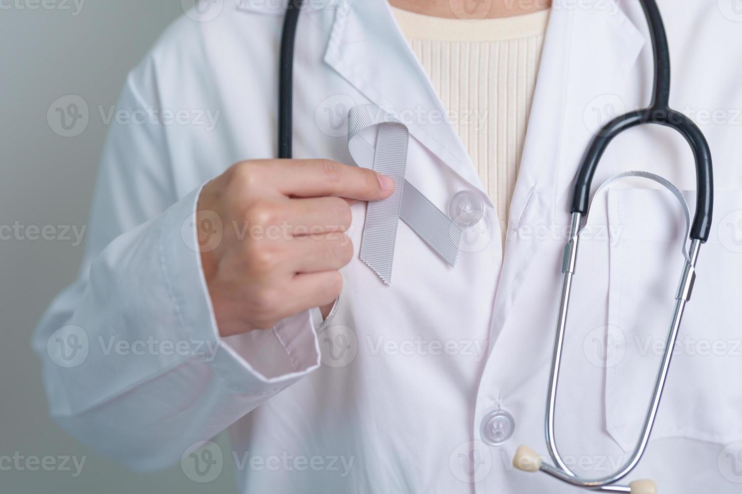 Brain Cancer Awareness May month, Doctor with grey color Ribbon for supporting life people. Healthcare and World cancer day concept photo