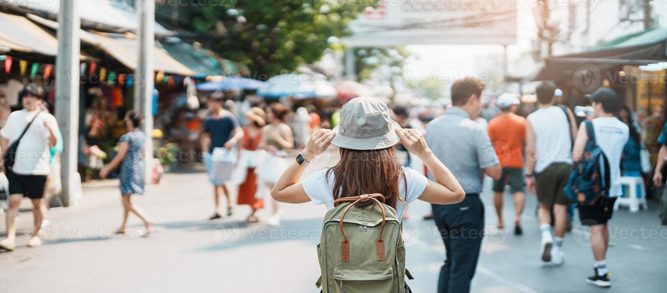 woman traveler visiting in Bangkok, Tourist with backpack and hat sightseeing in Chatuchak Weekend Market, landmark and popular attractions in Bangkok, Thailand. Travel in Southeast Asia concept photo