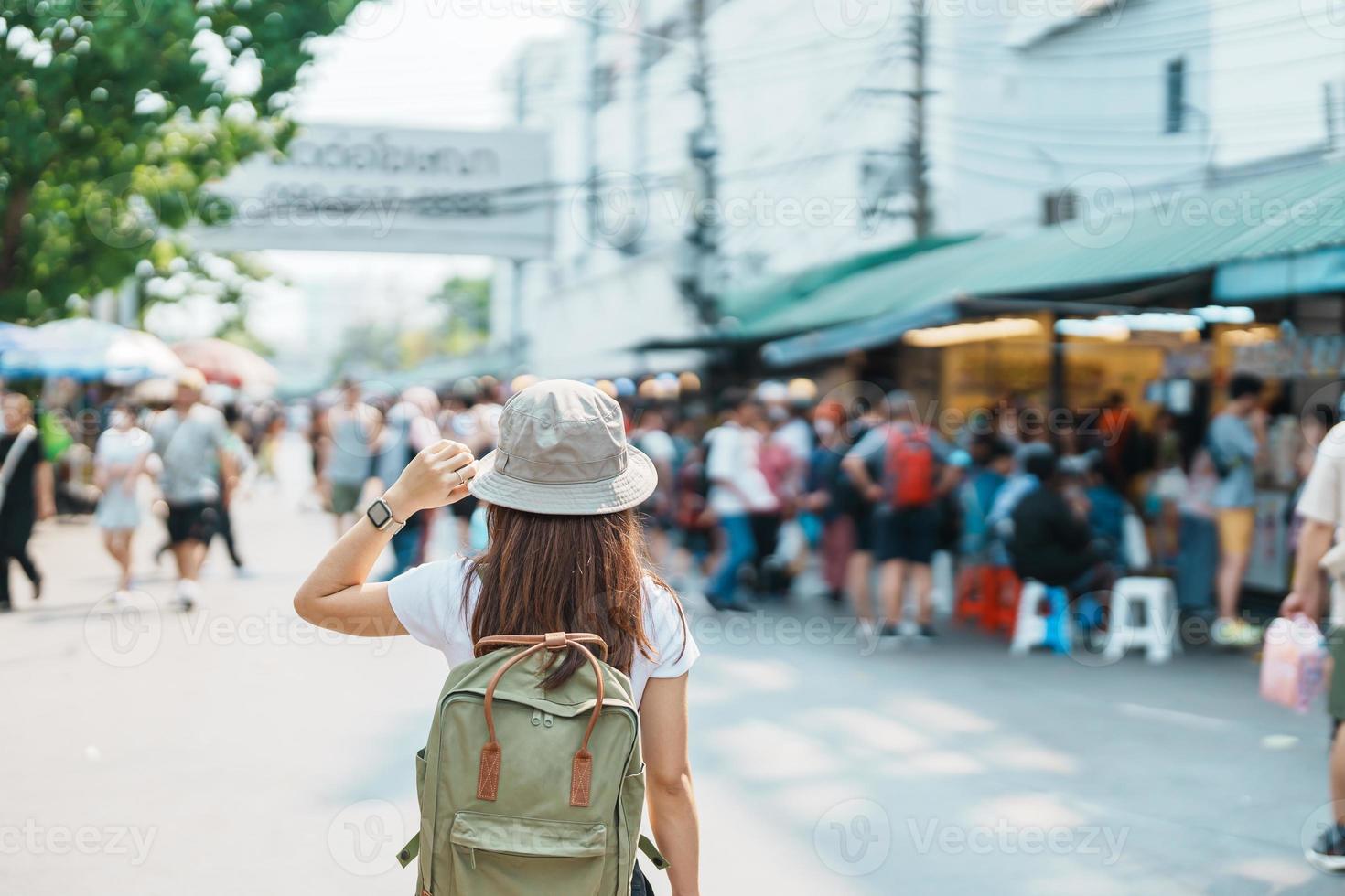 woman traveler visiting in Bangkok, Tourist with backpack and hat sightseeing in Chatuchak Weekend Market, landmark and popular attractions in Bangkok, Thailand. Travel in Southeast Asia concept photo