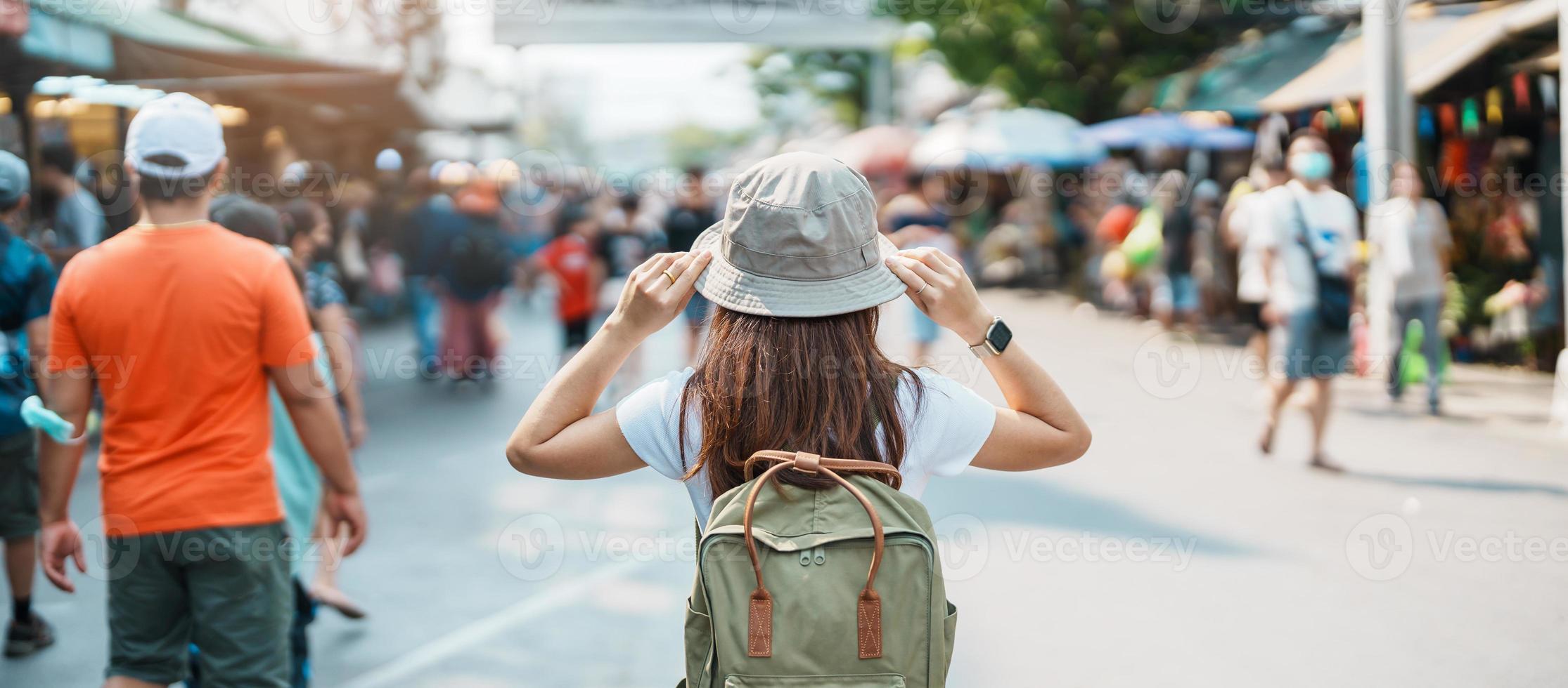 woman traveler visiting in Bangkok, Tourist with backpack and hat sightseeing in Chatuchak Weekend Market, landmark and popular attractions in Bangkok, Thailand. Travel in Southeast Asia concept photo