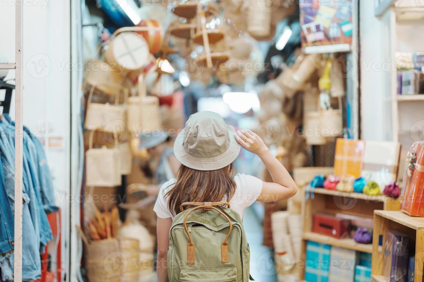 woman traveler visiting in Bangkok, Tourist with backpack and hat sightseeing in Chatuchak Weekend Market, landmark and popular attractions in Bangkok, Thailand. Travel in Southeast Asia concept photo