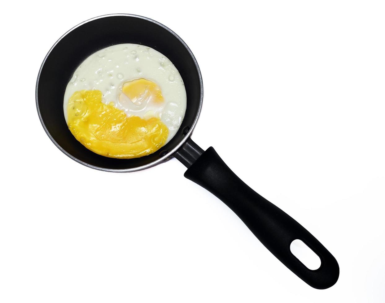 sunny side up eggs on a black pan isolated in white background photo