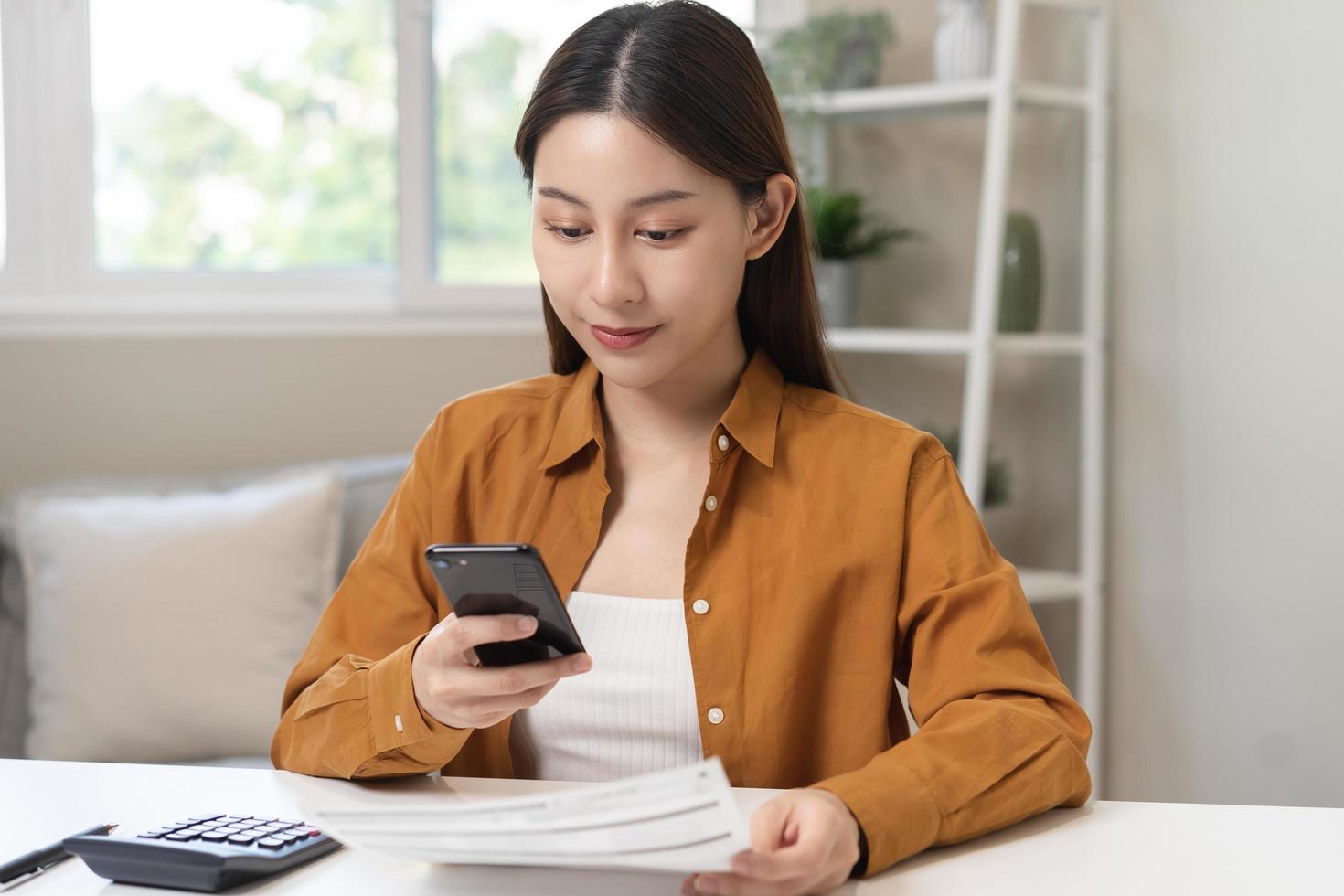 conveniencia en línea Internet bancario, asiático joven mujer mano en pago factura, gasto por escanear qr código, utilizar teléfono, móvil a transferir o pagar dinero de crédito tarjeta sin dinero en efectivo. tecnología de financiero. foto