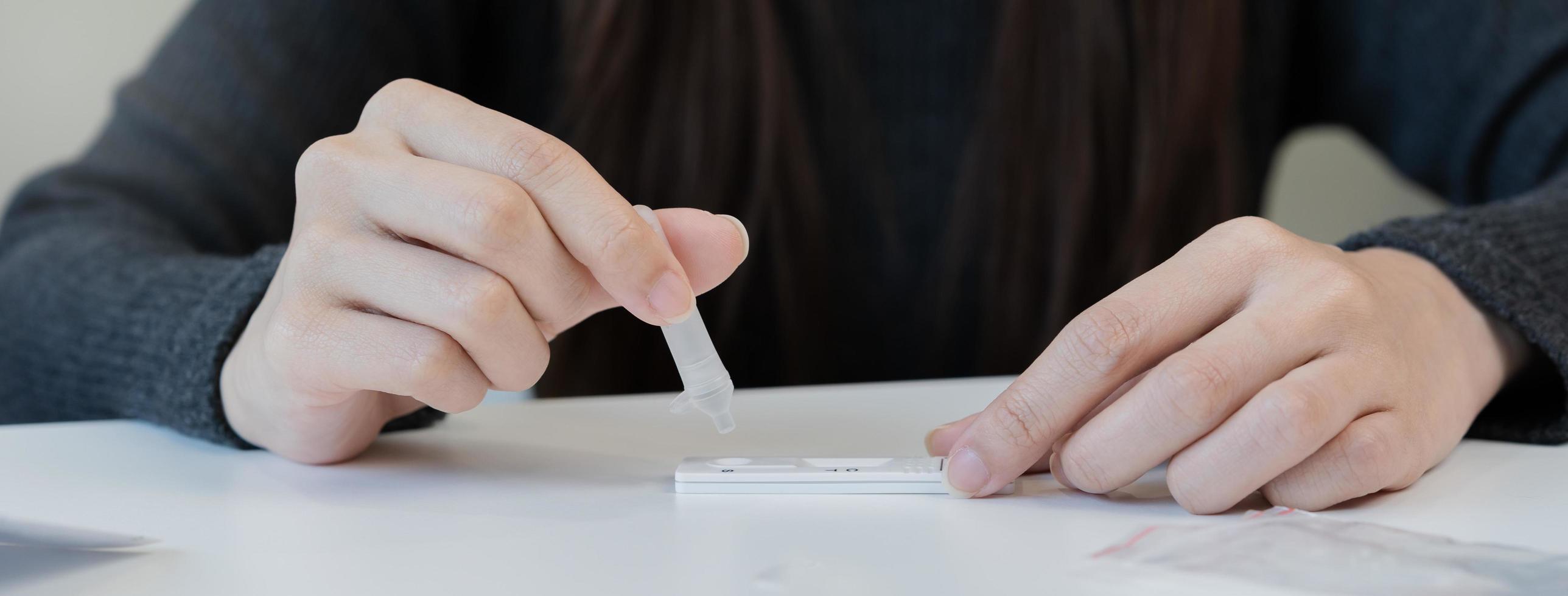 Pandemic of disease, asian young woman, girl hand holding atk, antigen kit self test. Introducing device nasal, nose swab test for possible infection of coronavirus, covid-19 at home. Health care. photo