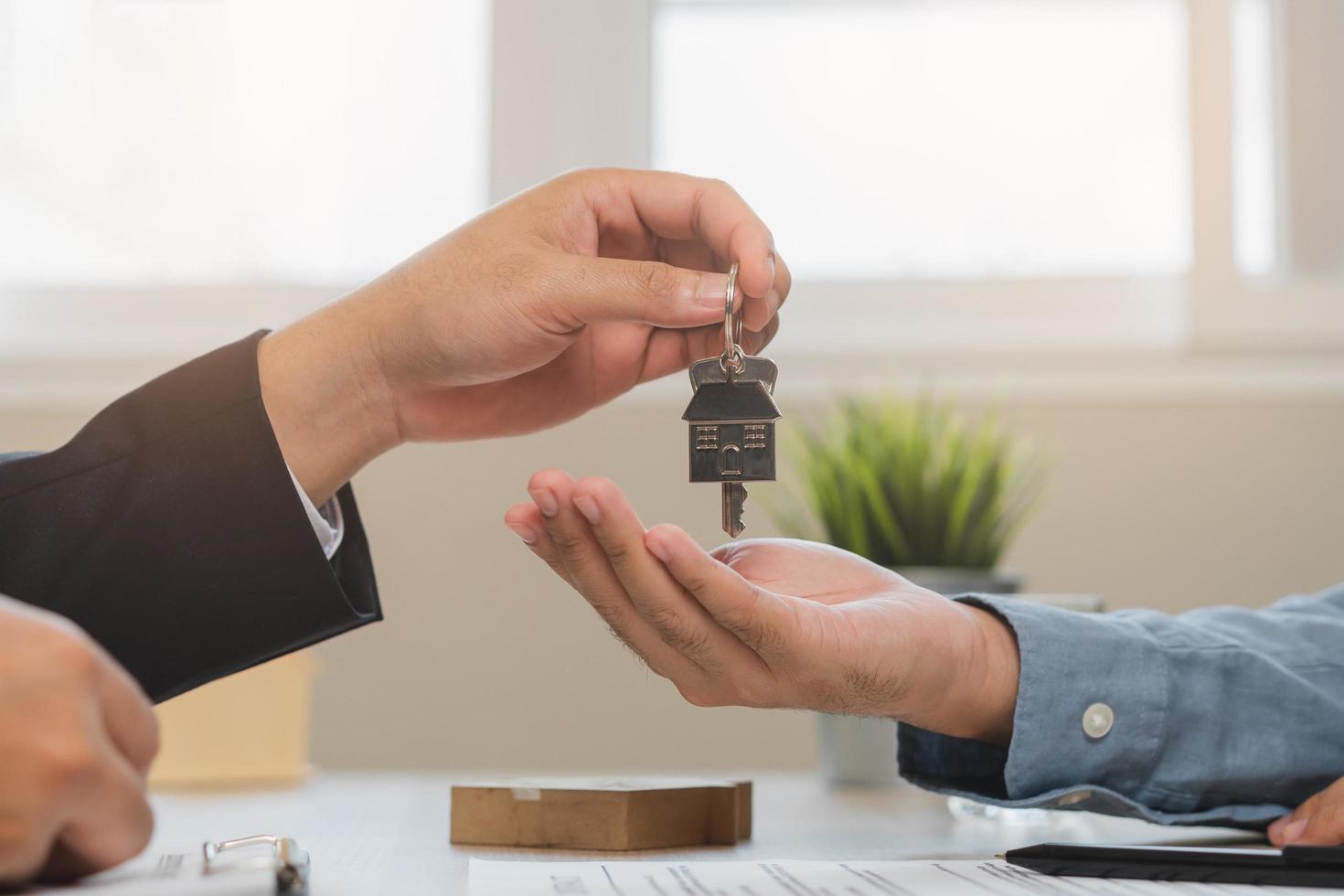 Asian agent giving a key to new owner or tenant, client after signed signature contract rental purchase, buyer apartment, home with landlord, realtor. Banker agreement mortgage loan. Property lease. photo