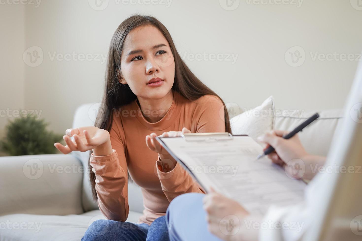 Psychology, depression. Sad, suffering asian young woman consulting with psychologist, psychiatrist while patient counseling mental with doctor woman taking notes at clinic. Encouraging, therapy. photo
