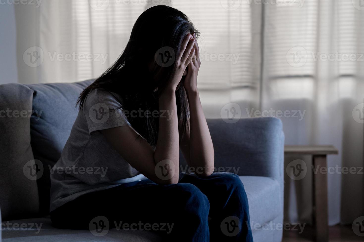 Mental health, depressed sad asian young woman, girl sitting on sofa, couch, expression to face difficulty, failure and exhausted. Thoughtful worried suffering depression feeling lonely, alone at home photo