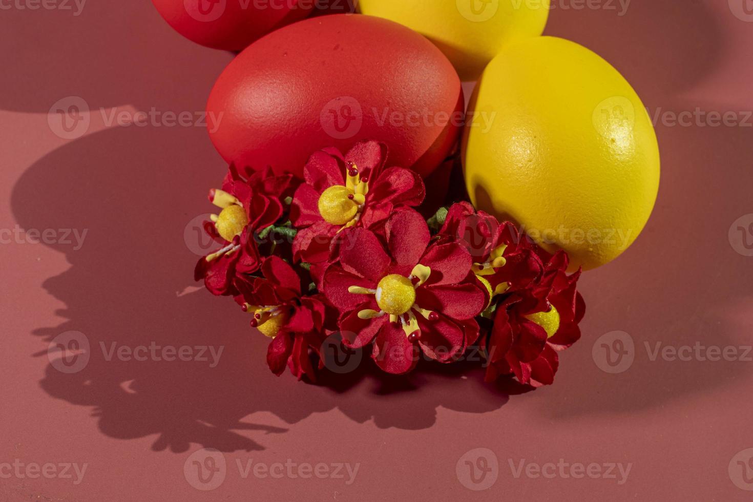 Colorful eggs, symbolizing Easter, on a colorful background and flowers photo