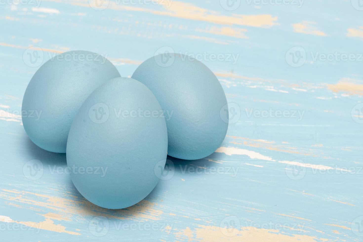 Eggs symbolizing the Easter holiday in blue color on a background of aged wood photo