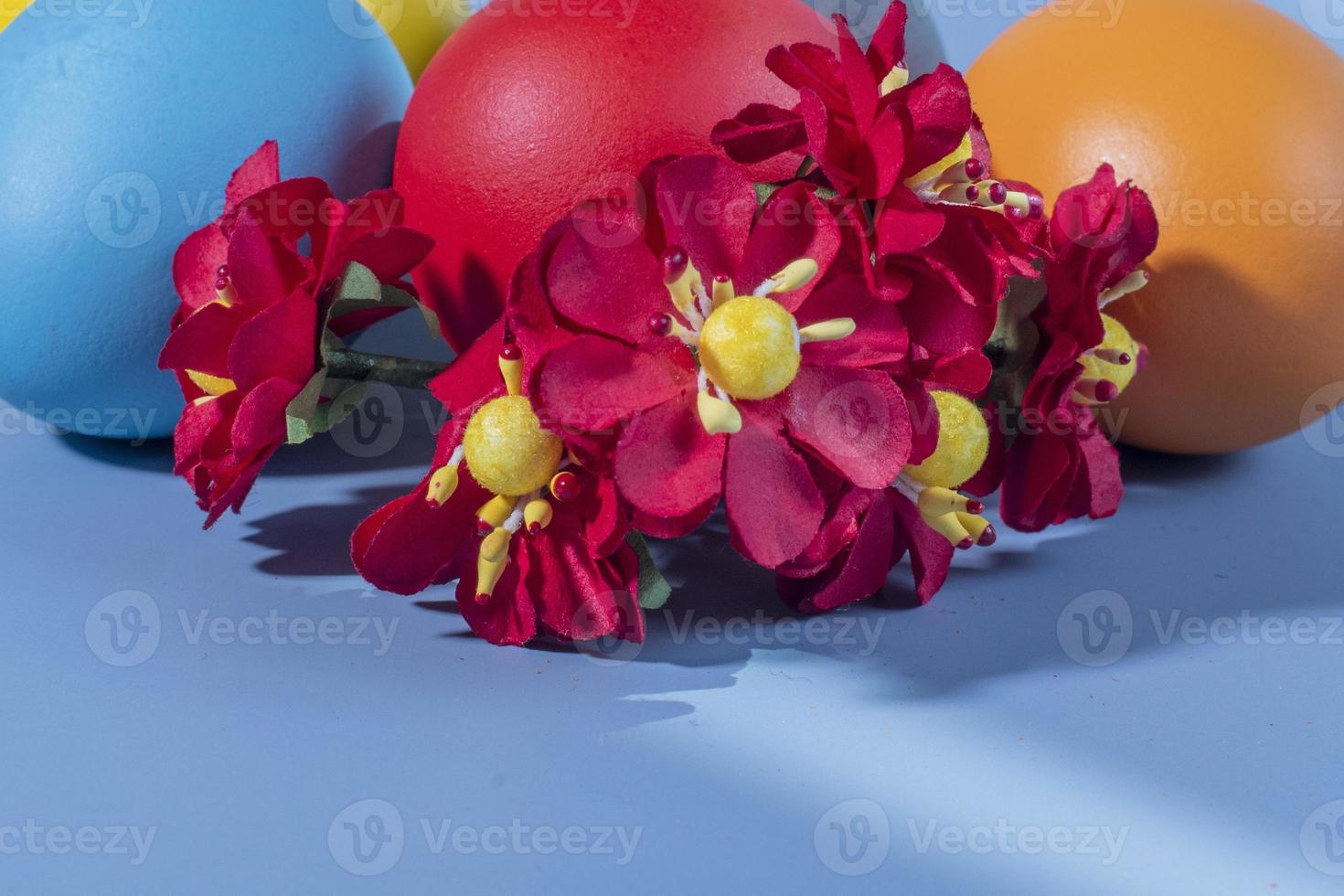 Colorful eggs, symbolizing Easter, on a colorful background and flowers photo