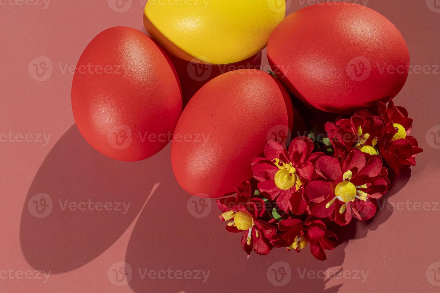 Colorful eggs, symbolizing Easter, on a colorful background and flowers photo
