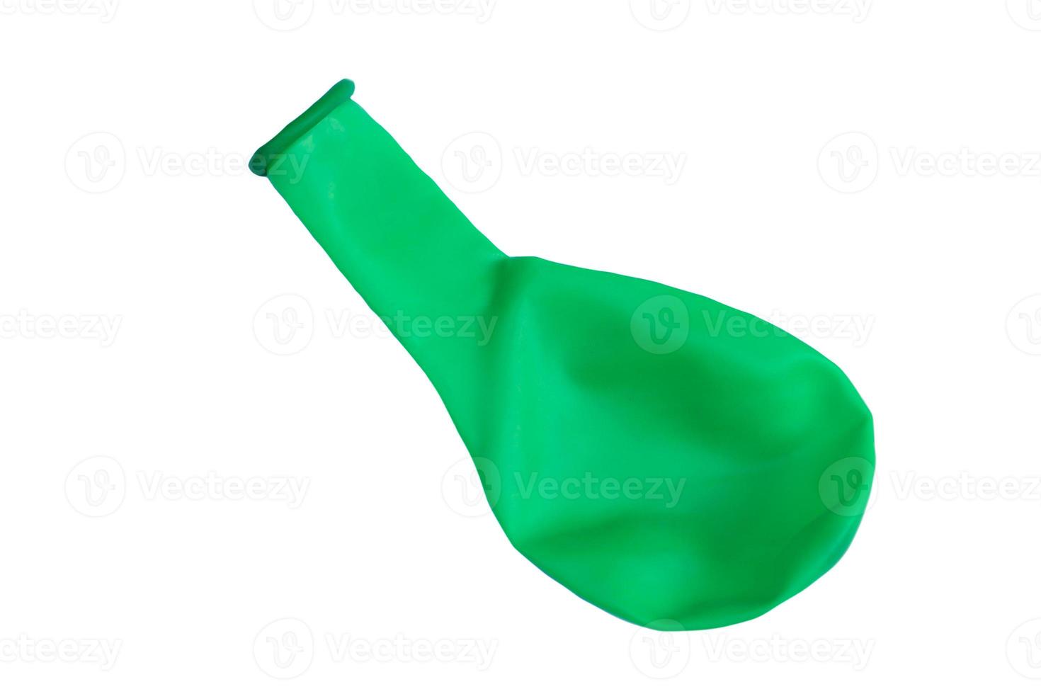 Green balloon without air to inflate isolated on white background. Concept,  toy and equipment to play fun games or prepare party. Deflated balloon. photo