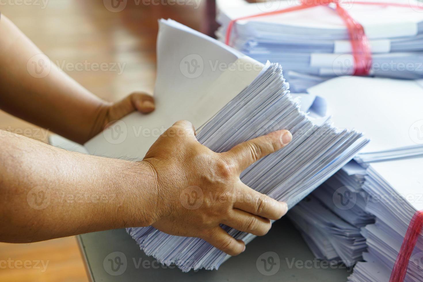 Closeup hands hold stack of used paper to recycle or combine to use next time to print out both sides of paper. Concept, eco friendly activity for environment, reuse paper. photo