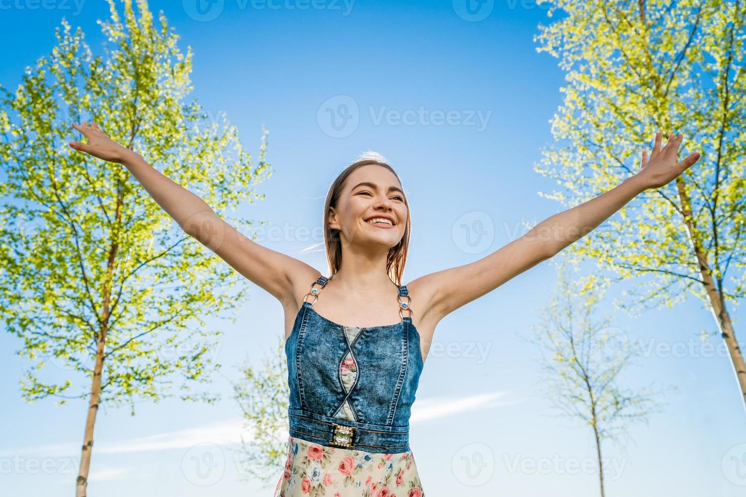 Attractive happy young woman long flowered dress flying her hair enjoying free photo