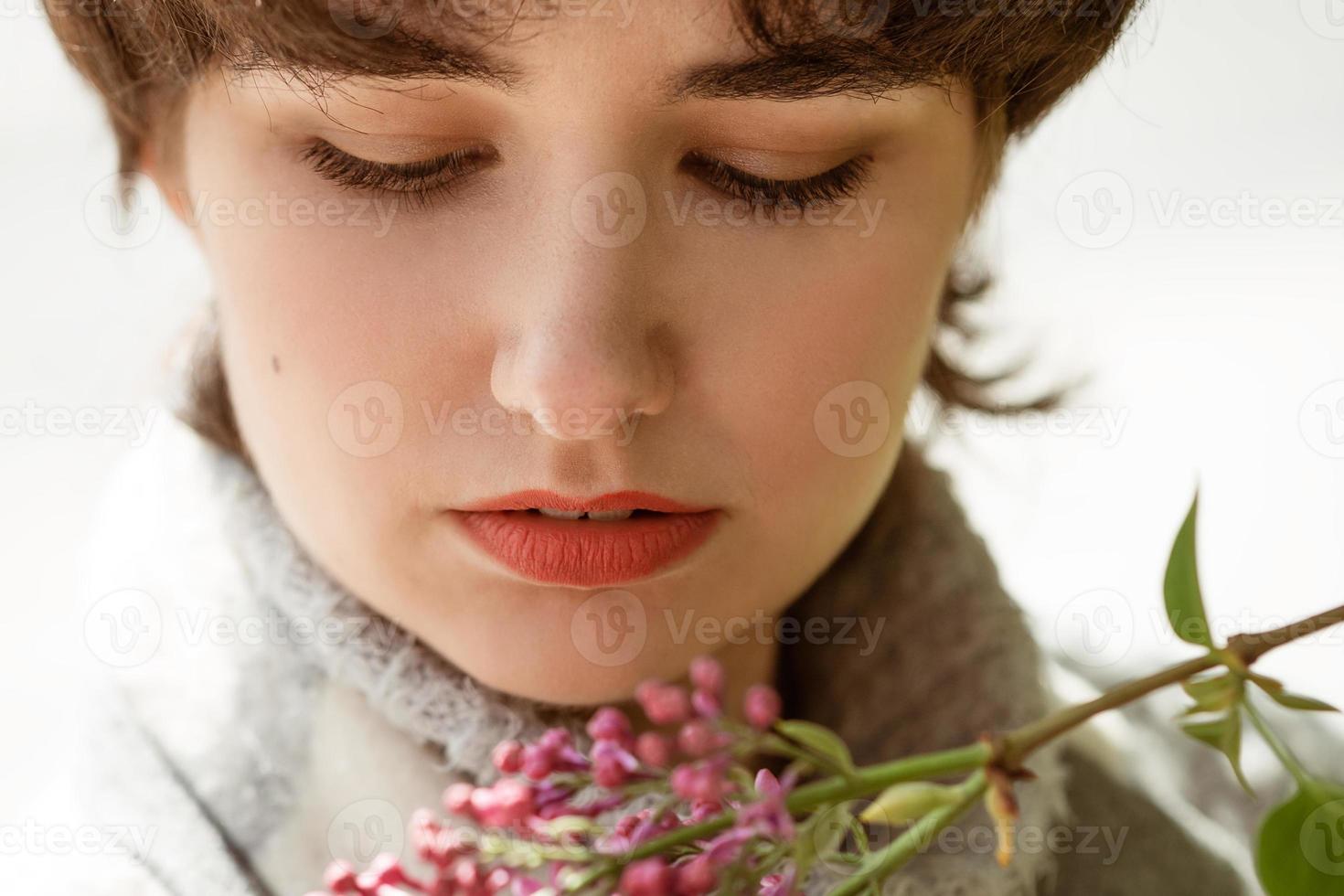 Portrait of a young woman in a lilac bush photo