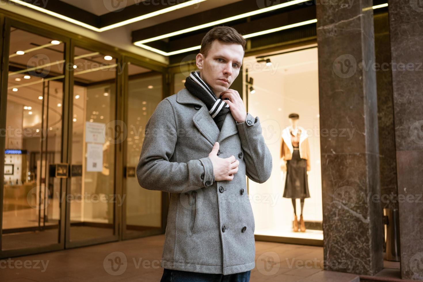 Young man walking down street, autumn or winter cold day. Outdoors, outside. photo