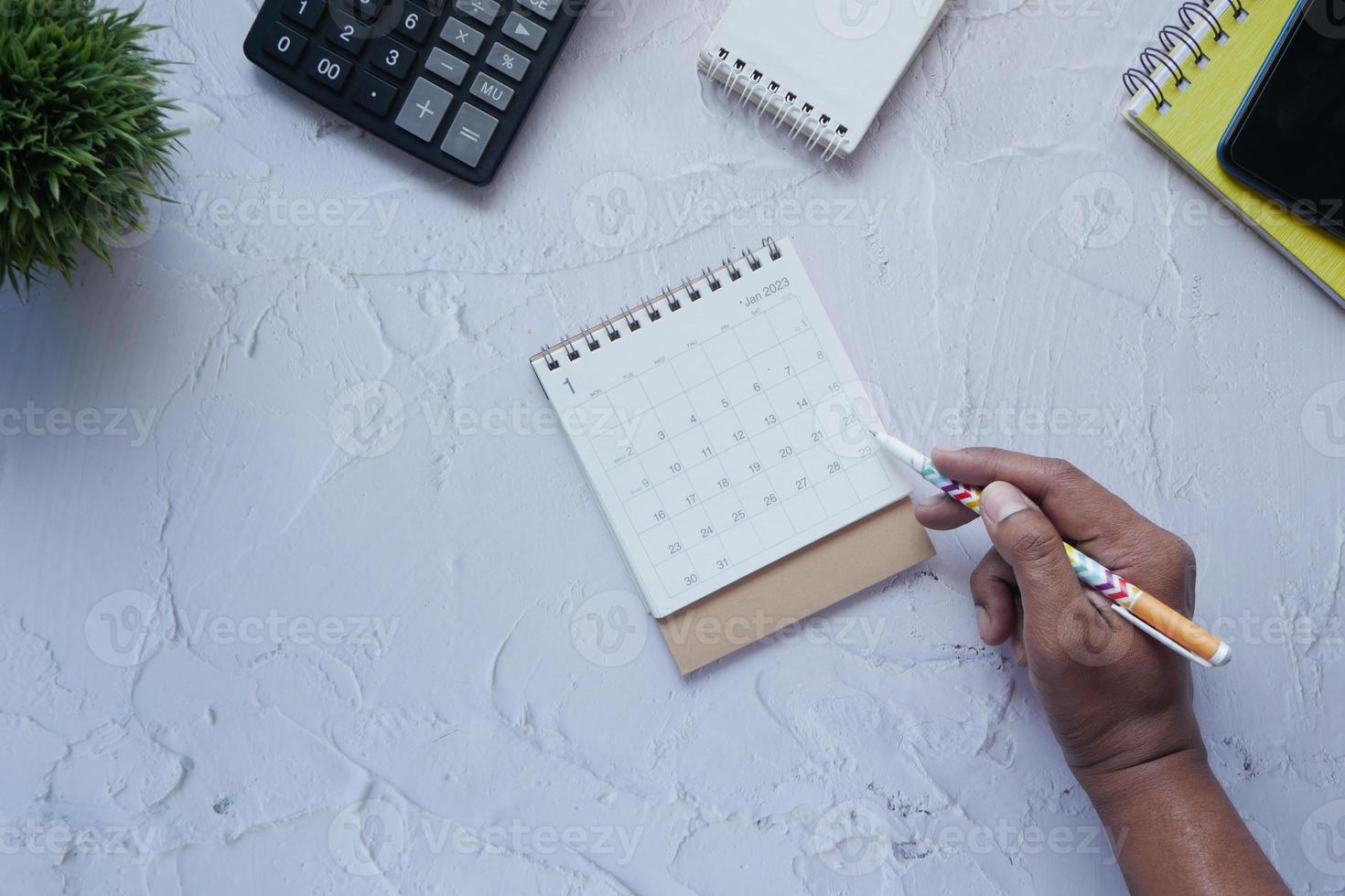 deadline concept with hand marking date on calendar top view photo