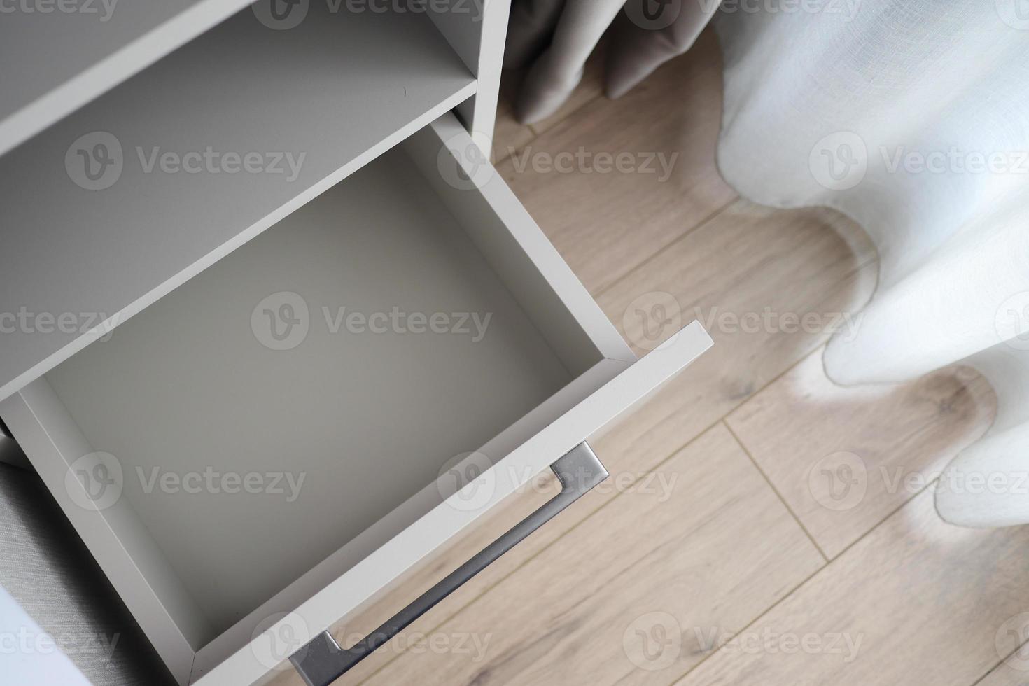 Opened kitchen drawer in room, top view photo