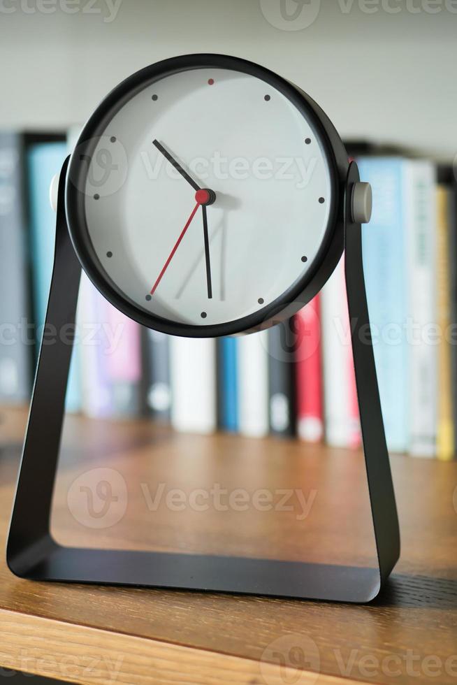 simple modern clock on a book shelf . photo