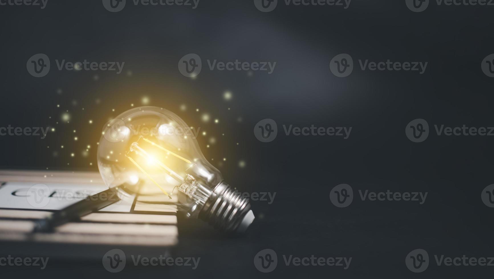 Thinking and creative concept, Light bulb on the Book and light bulb style bokeh vintage dark background,Concept The idea of reading books, knowledge, and searching for new ideas. photo