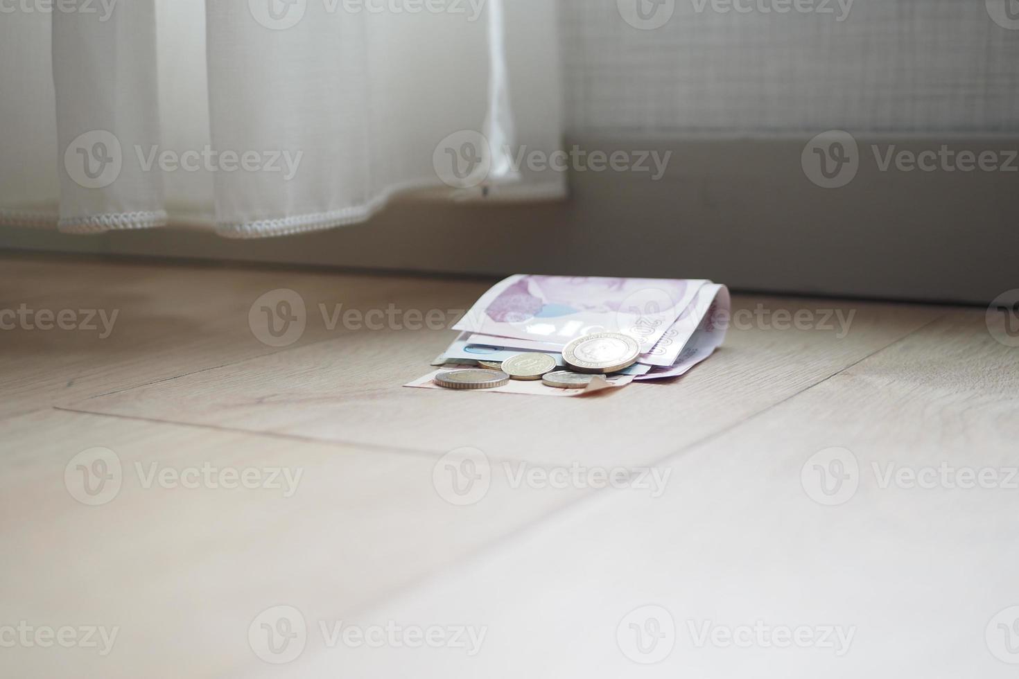 left cash and coins on floor at home photo