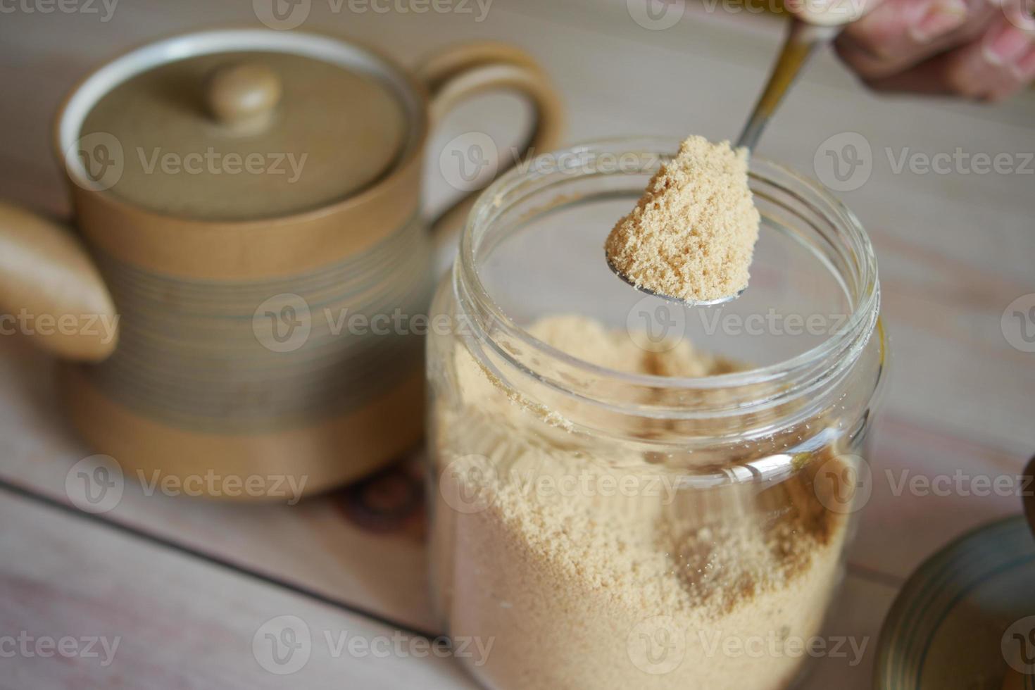 spoon pick brown sugar from a container photo
