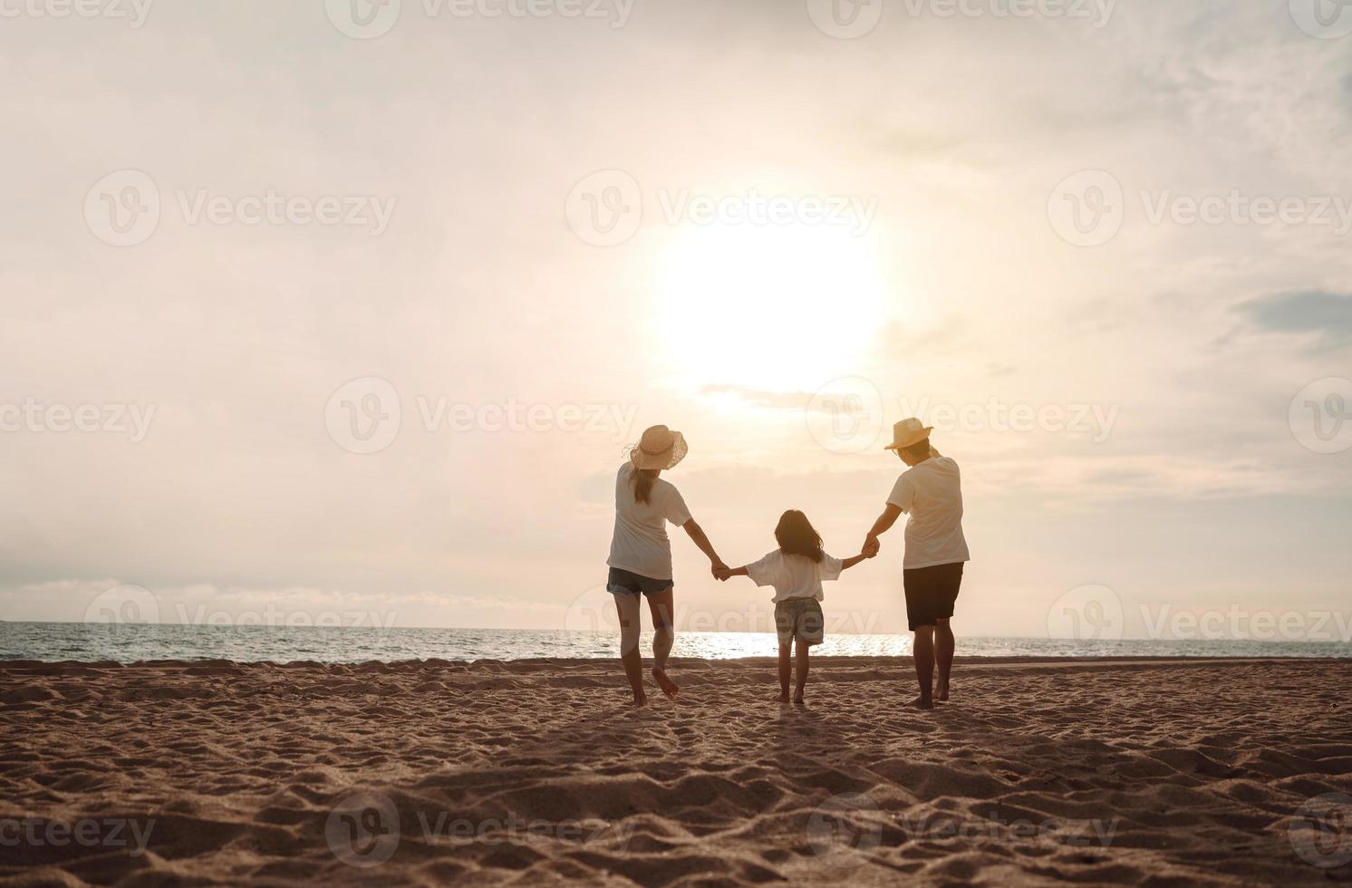 contento asiático familia disfrutar el mar playa a consistente padre, madre y hija teniendo divertido jugando playa en verano vacaciones en el Oceano playa. contento familia con vacaciones hora estilo de vida concepto. foto