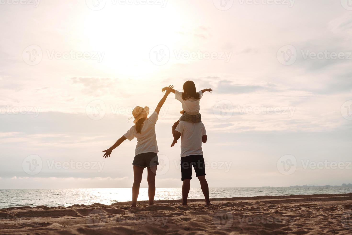 contento asiático familia disfrutar el mar playa a consistente padre, madre y hija teniendo divertido jugando playa en verano vacaciones en el Oceano playa. contento familia con vacaciones hora estilo de vida concepto. foto