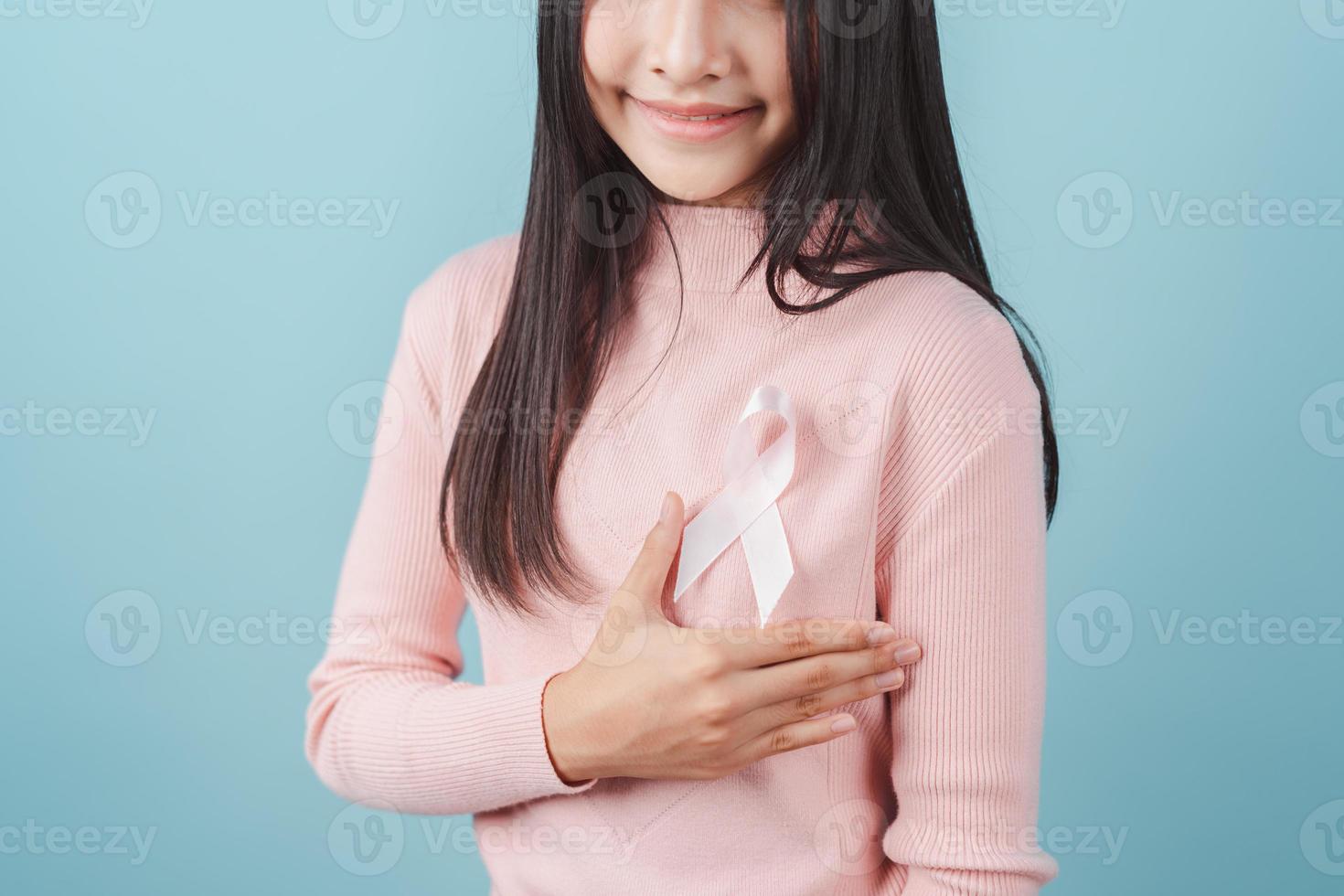 happy woman showing pink ribbon, Breast cancer awareness, world cancer day, national cancer survivor day in february concept. photo