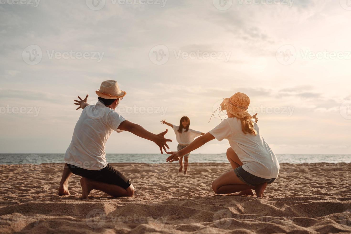 contento asiático familia disfrutar el mar playa a consistente padre, madre y hija teniendo divertido jugando playa en verano vacaciones en el Oceano playa. contento familia con vacaciones hora estilo de vida concepto. foto