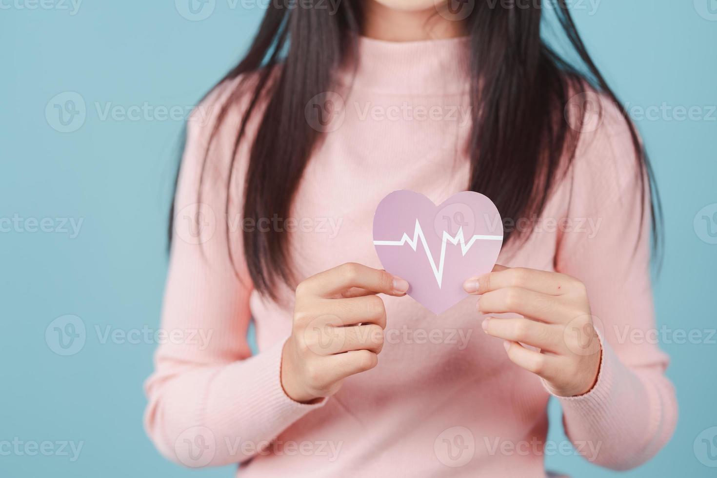 woman holding heart anatomy paper cut, heart attack, heart disease, Female with health care and Healthy feminine, World Heart Day concept. photo