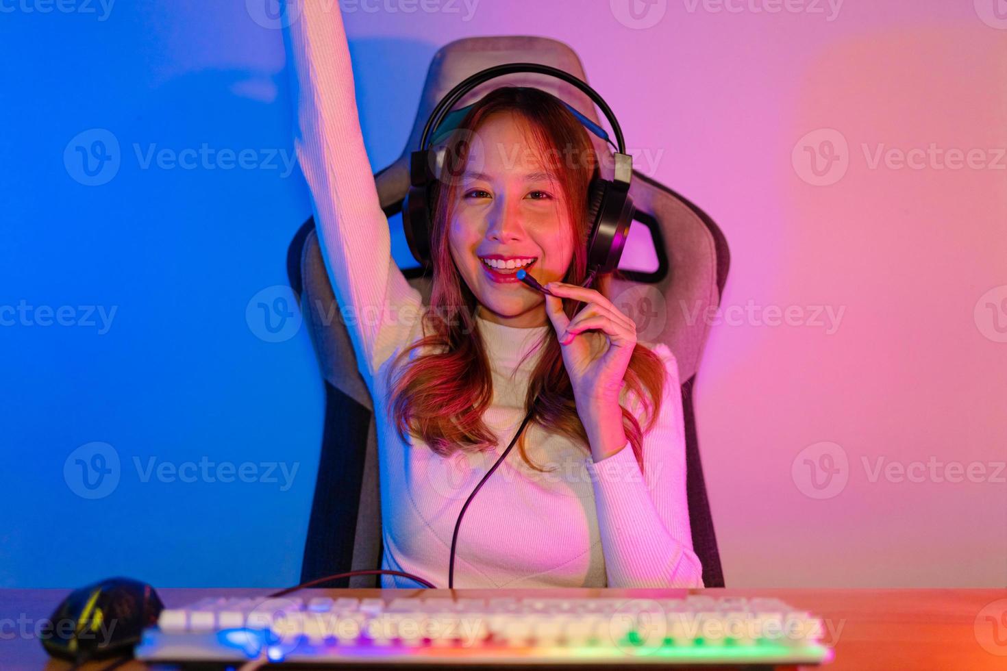 Asian gamer playing online video game winning excited on PC with lighting effect, broadcast streaming live at home. Gamer and E-Sport online gaming technology Championship tournament gamer concept. photo
