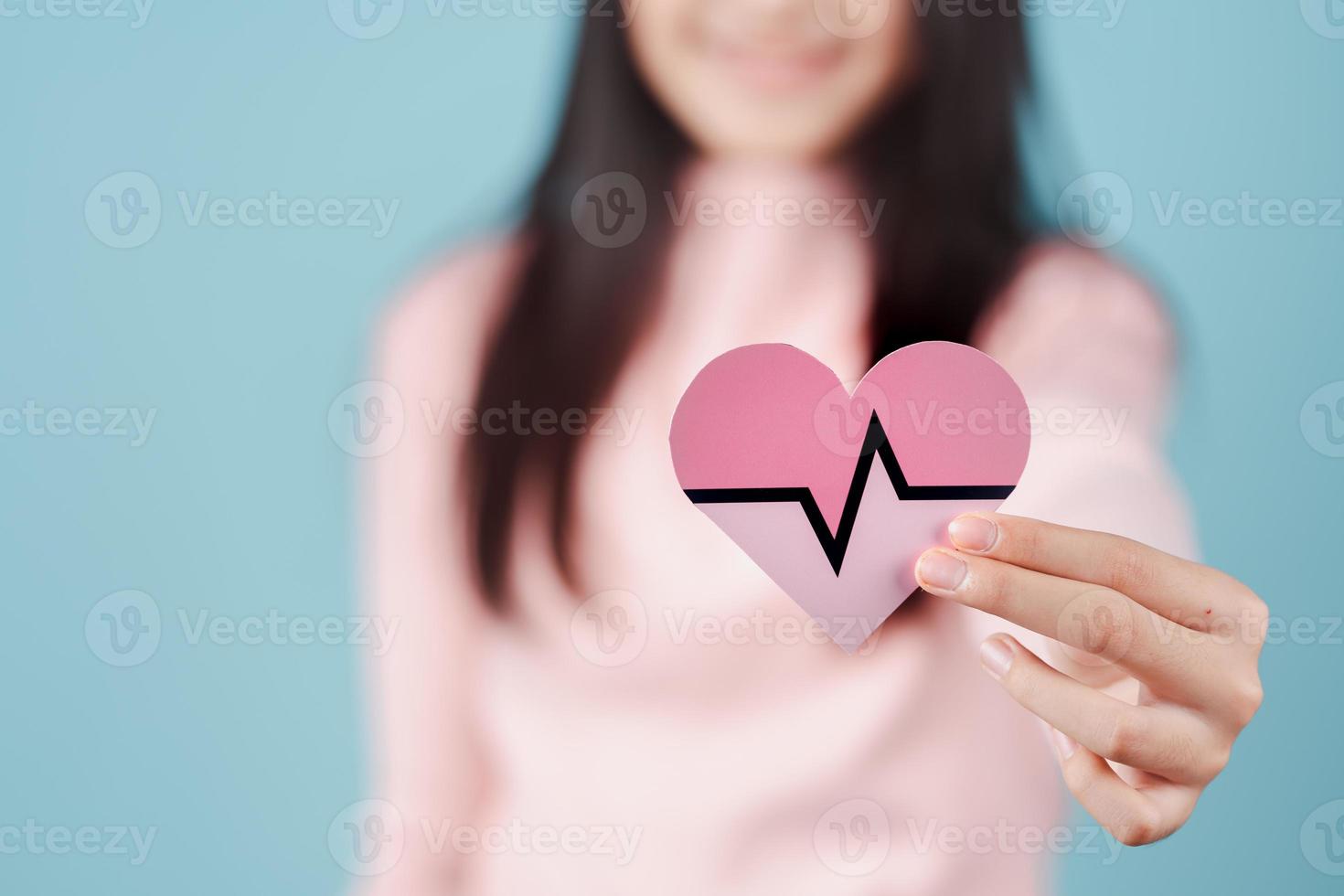 woman holding heart anatomy paper cut, heart attack, heart disease, Female with health care and Healthy feminine, World Heart Day concept. photo