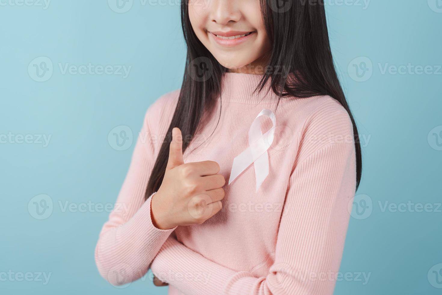 happy woman showing pink ribbon, Breast cancer awareness, world cancer day, national cancer survivor day in february concept. photo