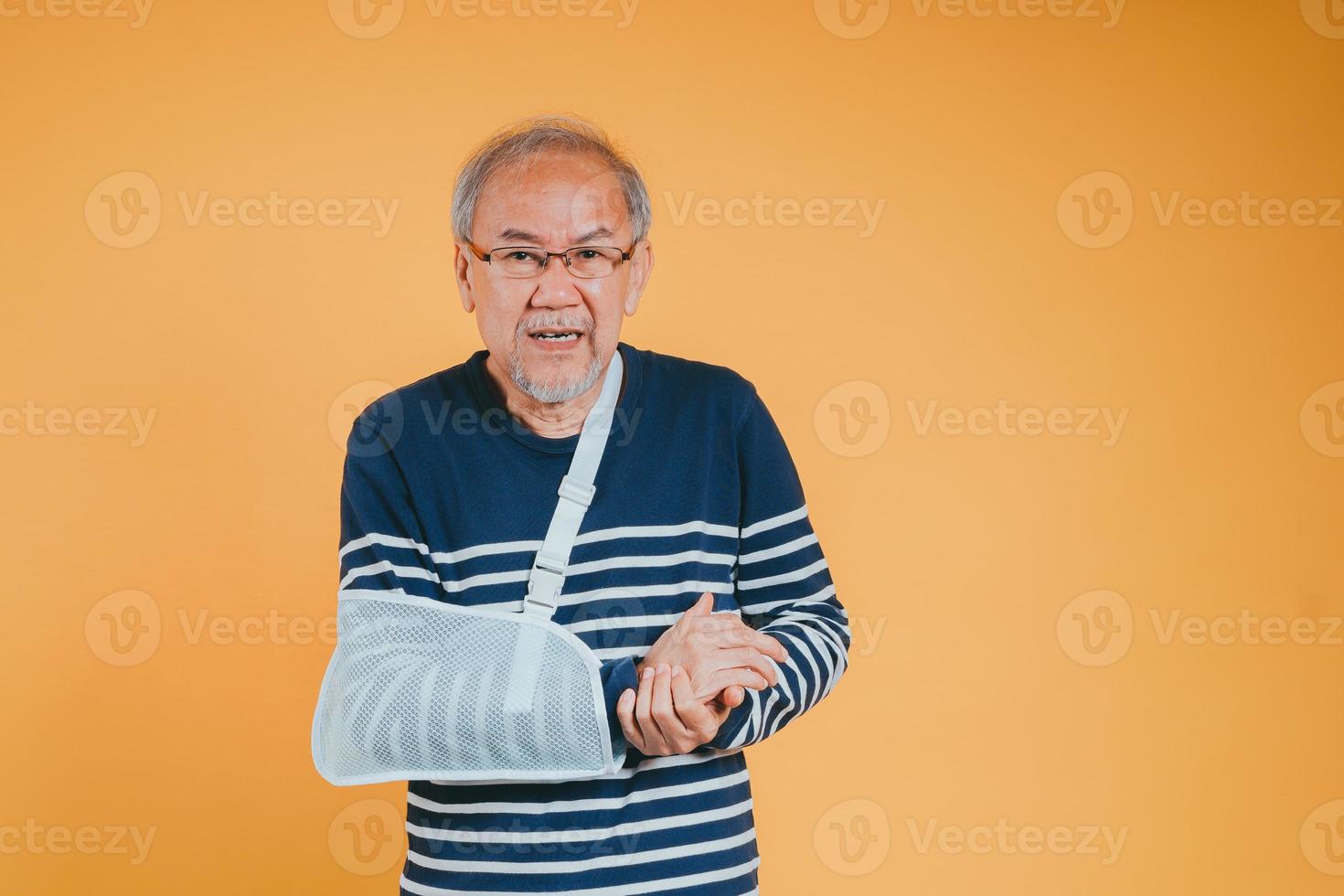 Arm broken. Senior male sling support hand confident smile broken after accident wear arm splint for treatment show good sign. health insurance on mobile concept. photo