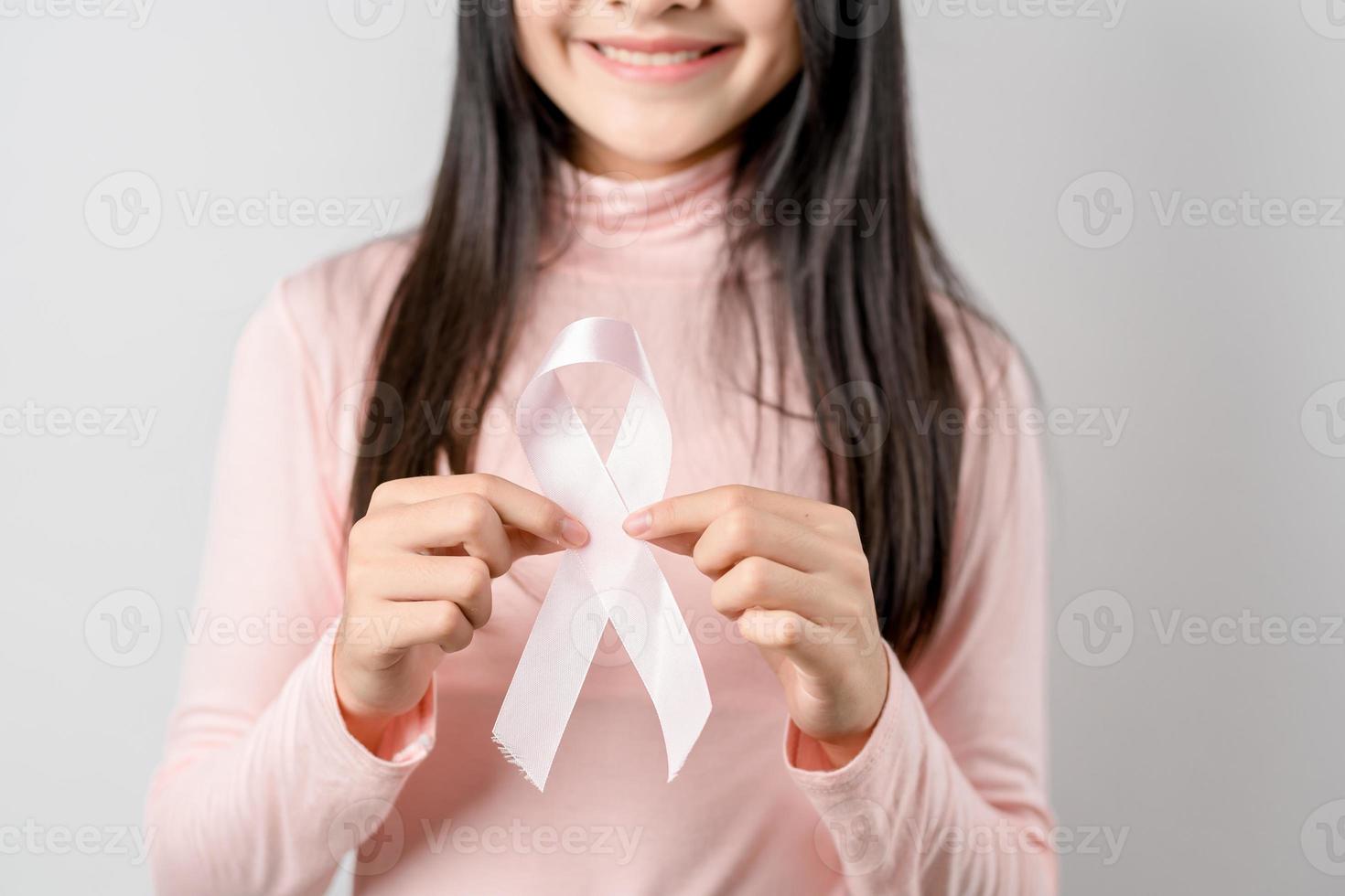 woman hands holding pink ribbon, Breast cancer awareness, world cancer day, national cancer survivor day in february concept. photo