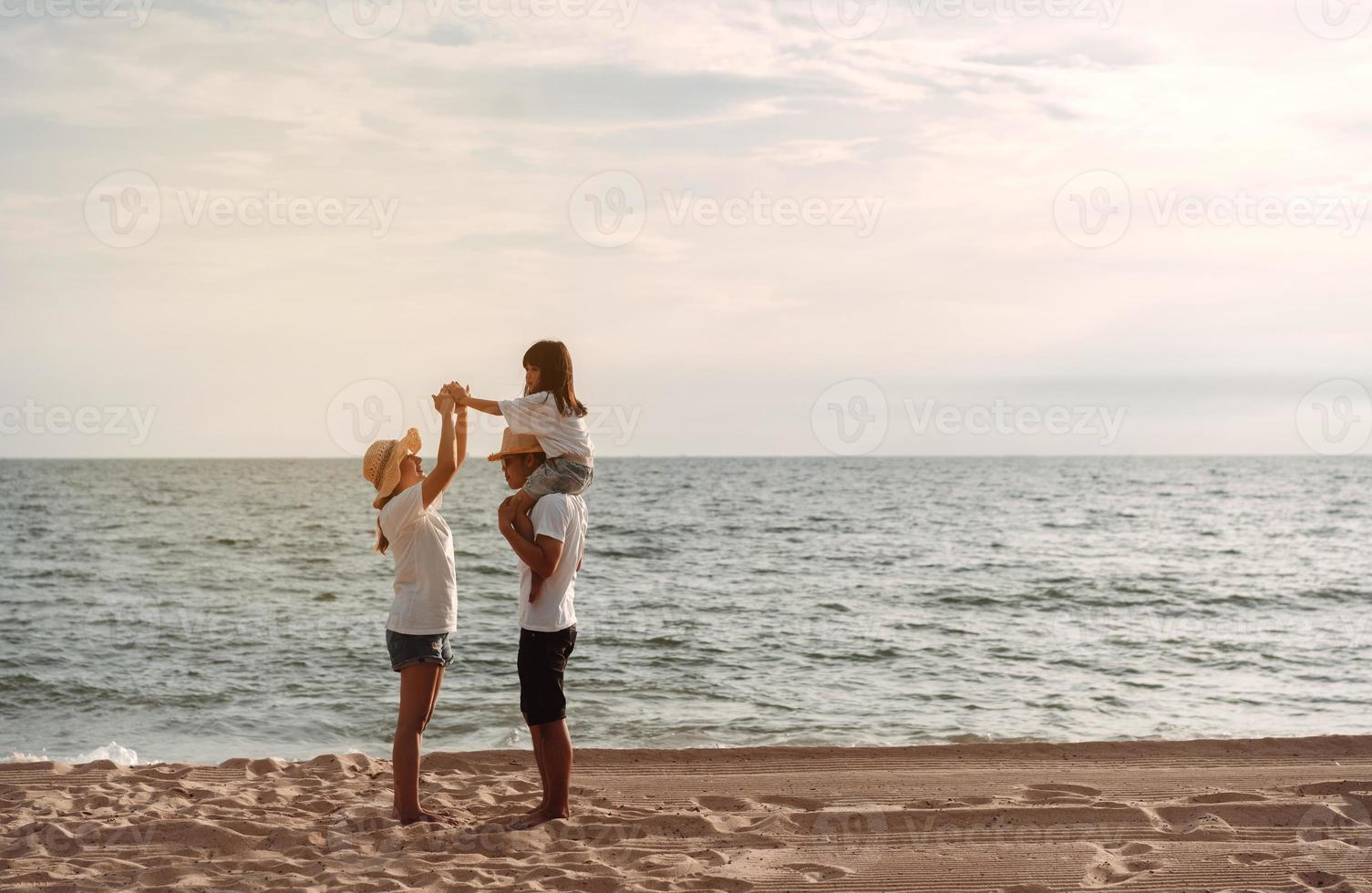contento asiático familia disfrutar el mar playa a consistente padre, madre y hija teniendo divertido jugando playa en verano vacaciones en el Oceano playa. contento familia con vacaciones hora estilo de vida concepto. foto
